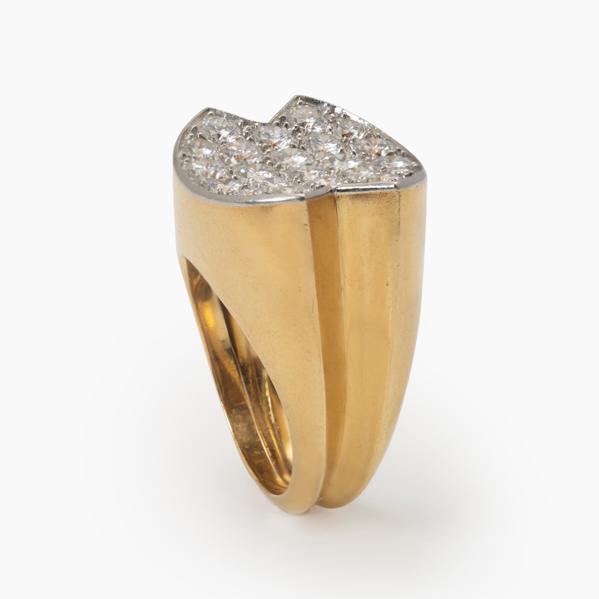 An eighteen-carat yellow gold ring, with a concave platinum top, set with brilliant-cut diamonds. Signed Cartier Paris and numbered. Made ca 1960.