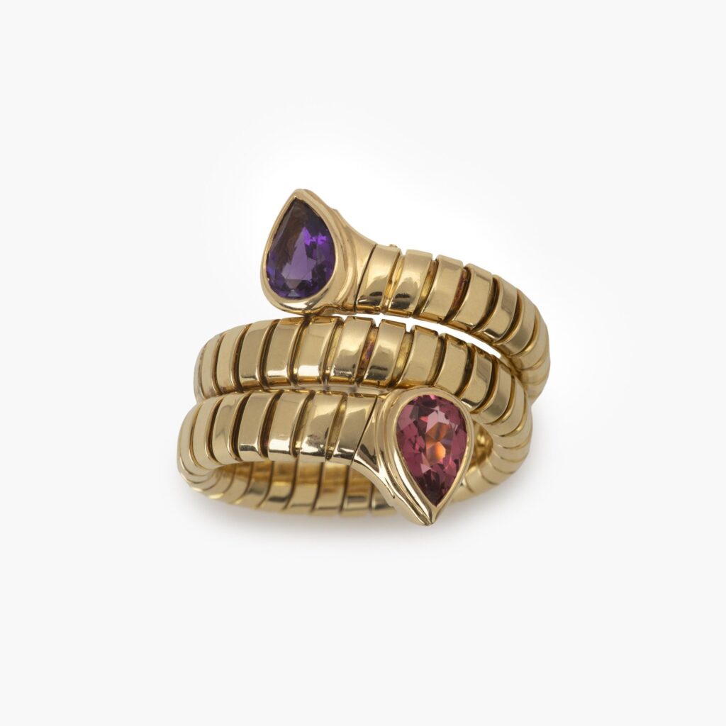 An eighteen carat yellow gold flexible ‘Tubogas’ ring, set with amethyst and tourmaline. Signed Bvlgari, made in Italy. With original receipt dated 1996.
