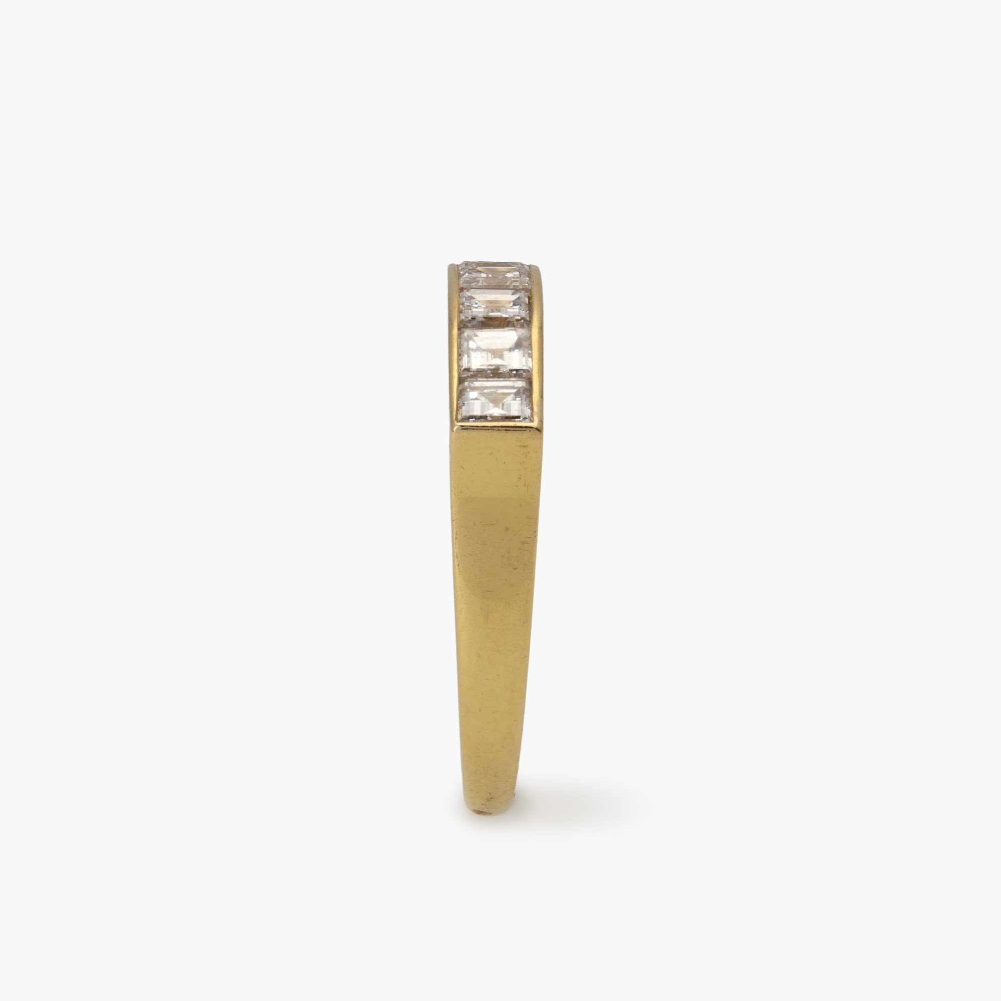 An eighteen carat yellow gold ring with a ondulating top, set with square-cut diamonds in a rail setting. Signed Cartier Paris and numbered. Made ca 1975.