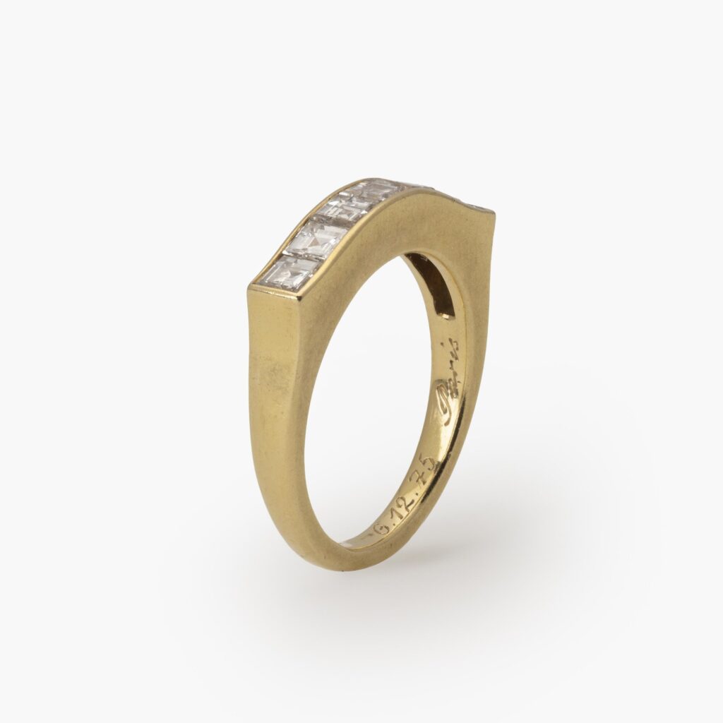An eighteen carat yellow gold ring with a ondulating top, set with square-cut diamonds in a rail setting. Signed Cartier Paris and numbered. Made ca 1975.