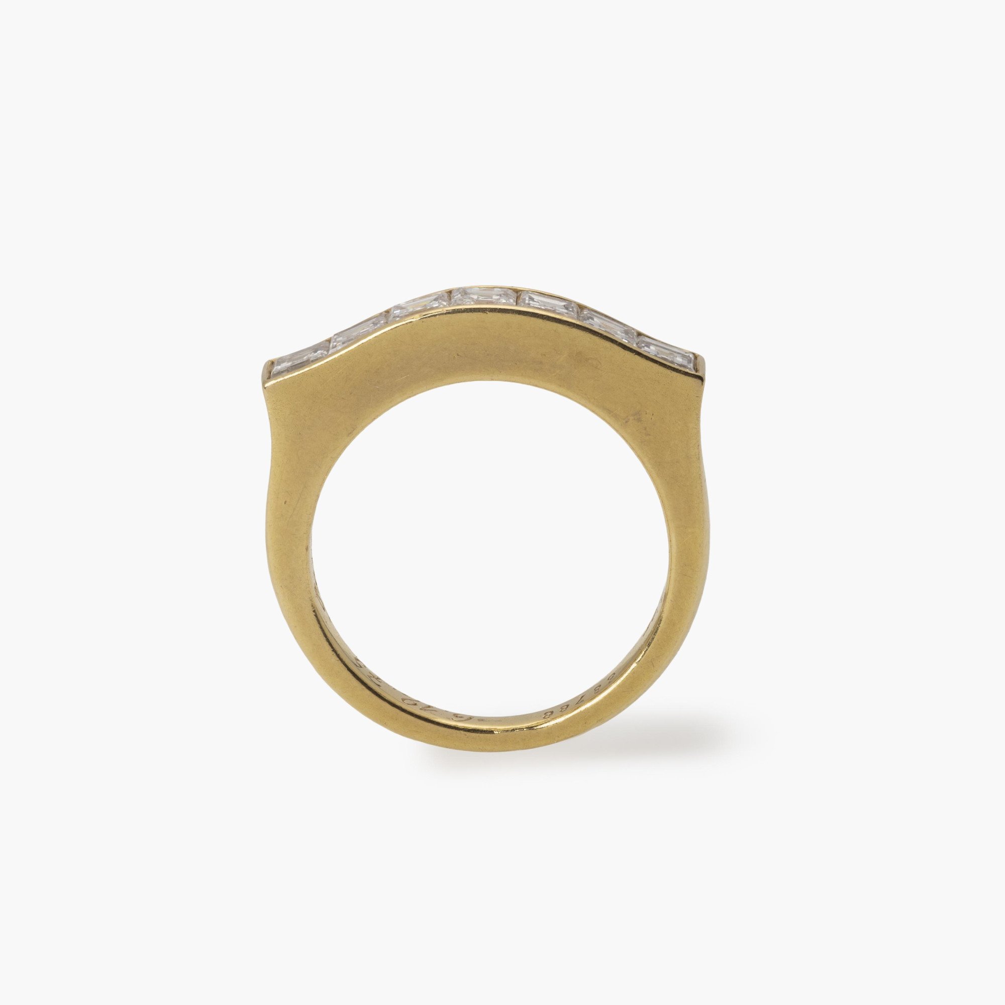 An eighteen carat yellow gold ring with a ondulating top, set with square-cut diamonds in a rail setting. Signed Cartier Paris and numbered. Made ca 1975.