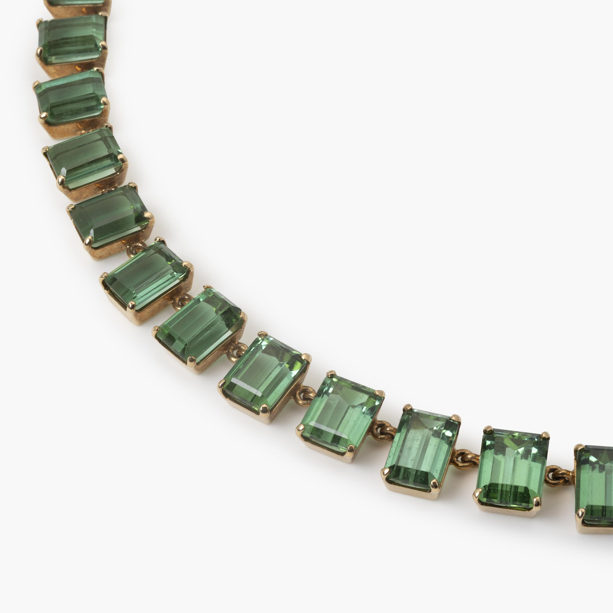 A fourteen karat yellow gold rivière necklace featuring 44 emeraude-cut green tourmalines, made ca 1980.
