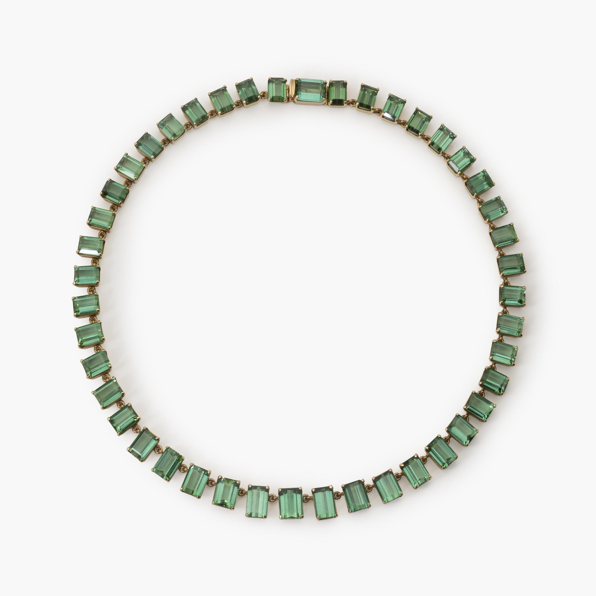 A fourteen karat yellow gold rivière necklace featuring 44 emeraude-cut green tourmalines, made ca 1980.