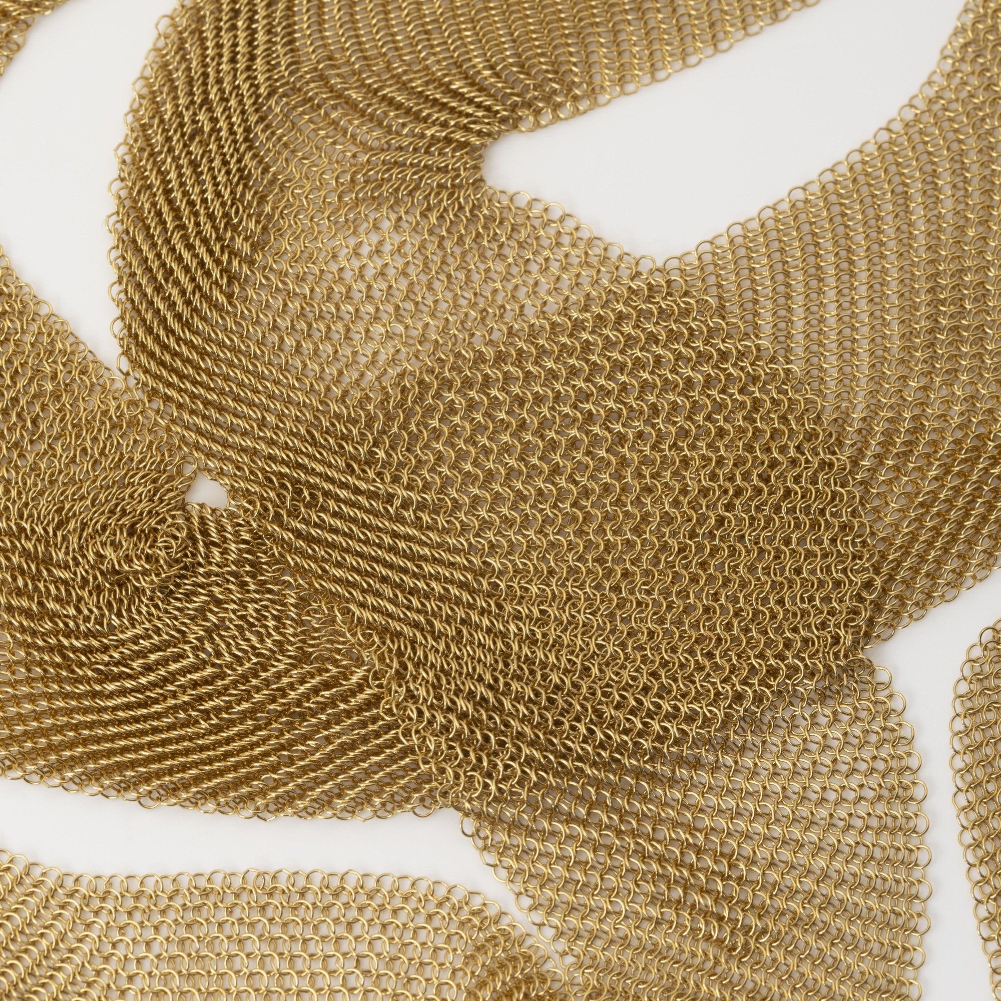 An eighteen carat yellow gold necklace designed as a scarf, signed Elsa Peretti for Tiffany & Co., made in the USA, ca 1980. With original pouch.