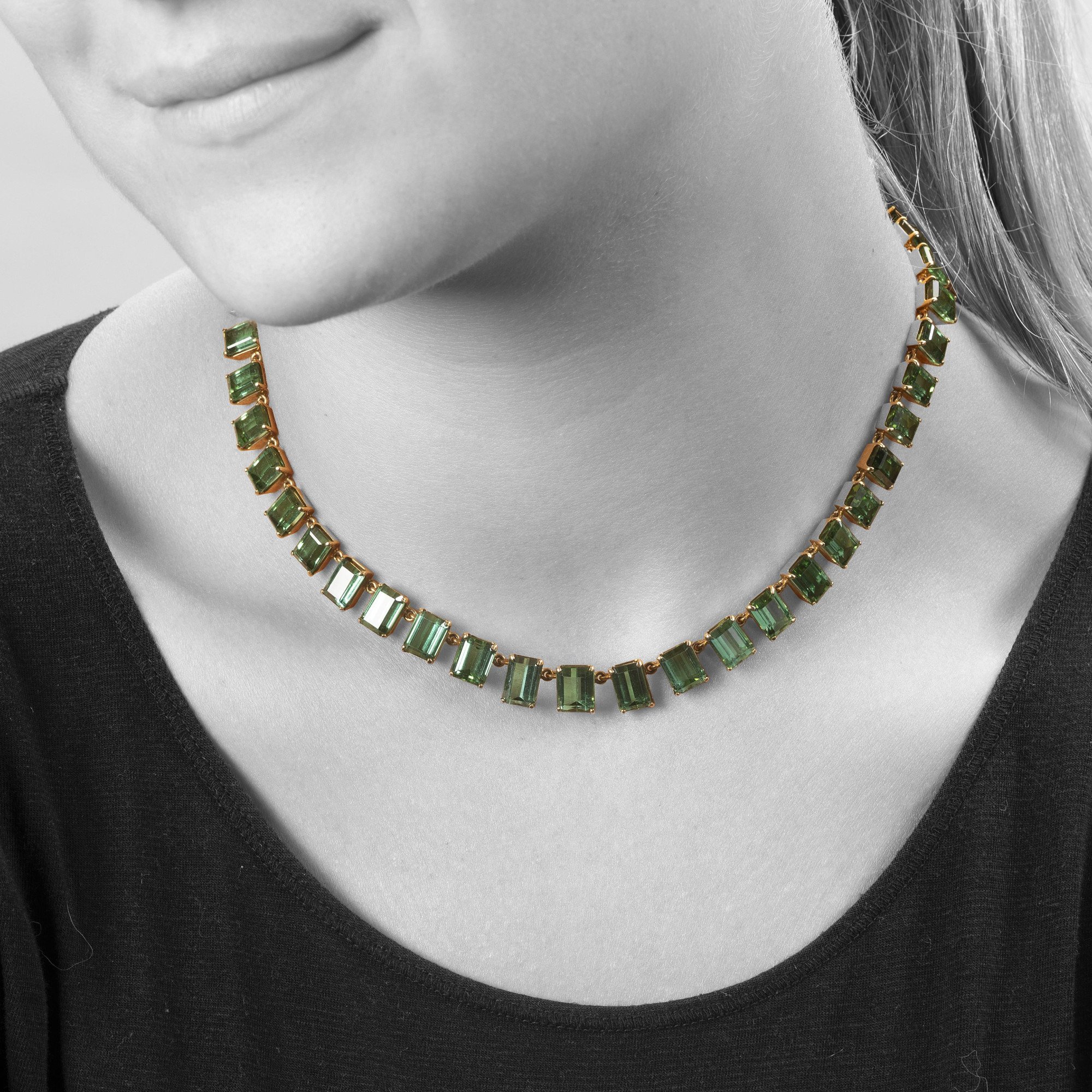A fourteen karat yellow gold rivière necklace featuring 44 emeraude-cut green tourmalines, made ca 1980.